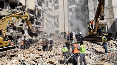 EPA emergency workers use excavators to clear debris from a site targeted by an Israeli strike yesterday, in a village south of Beirut, Lebanon.