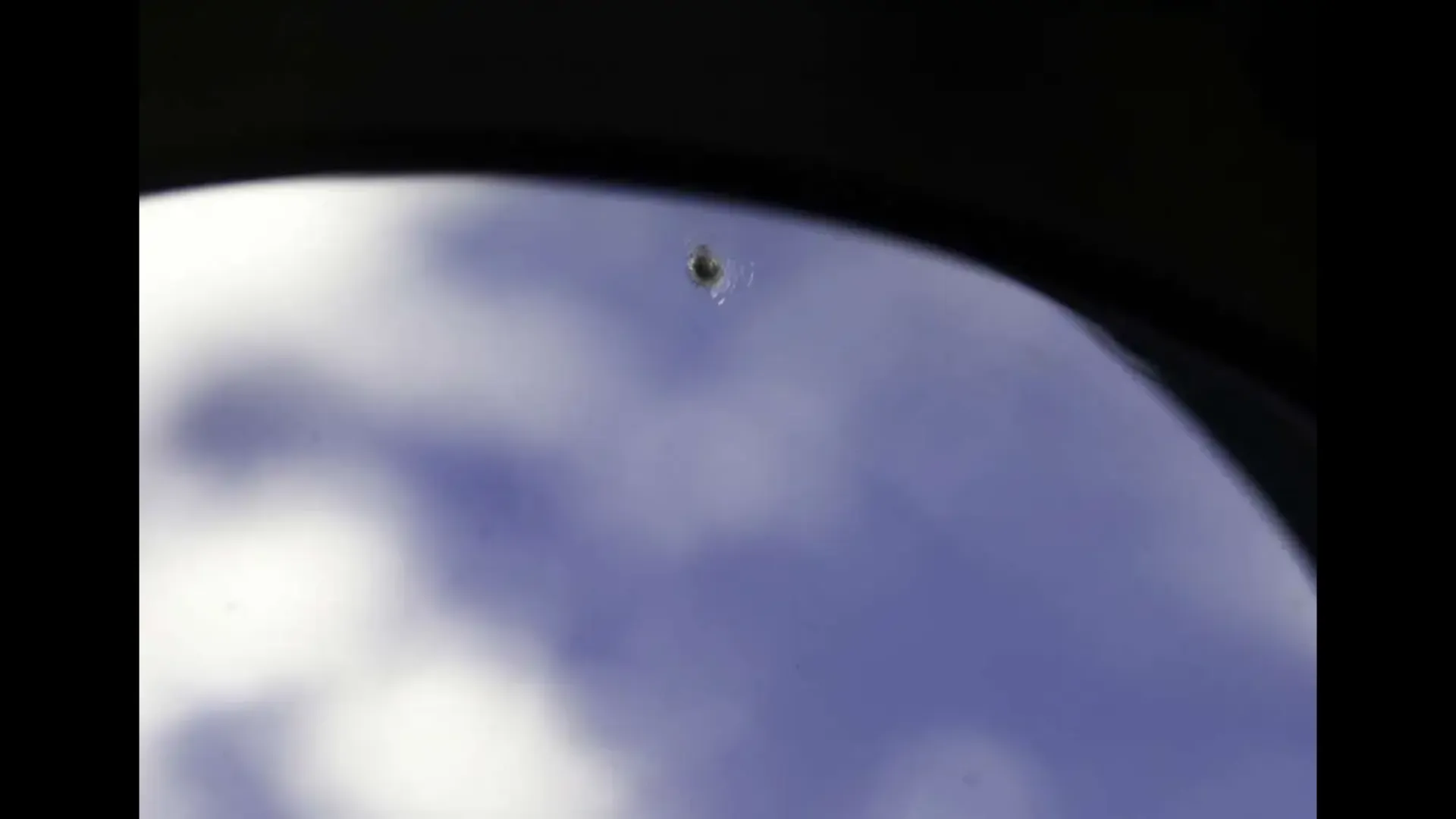 A small lump like a bullet hole on the window.