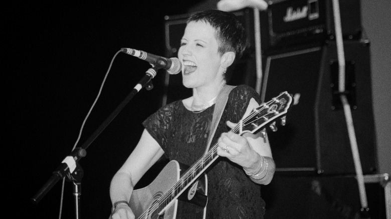 Dolores O'Riordan of The Cranberries plays guitar on stage
