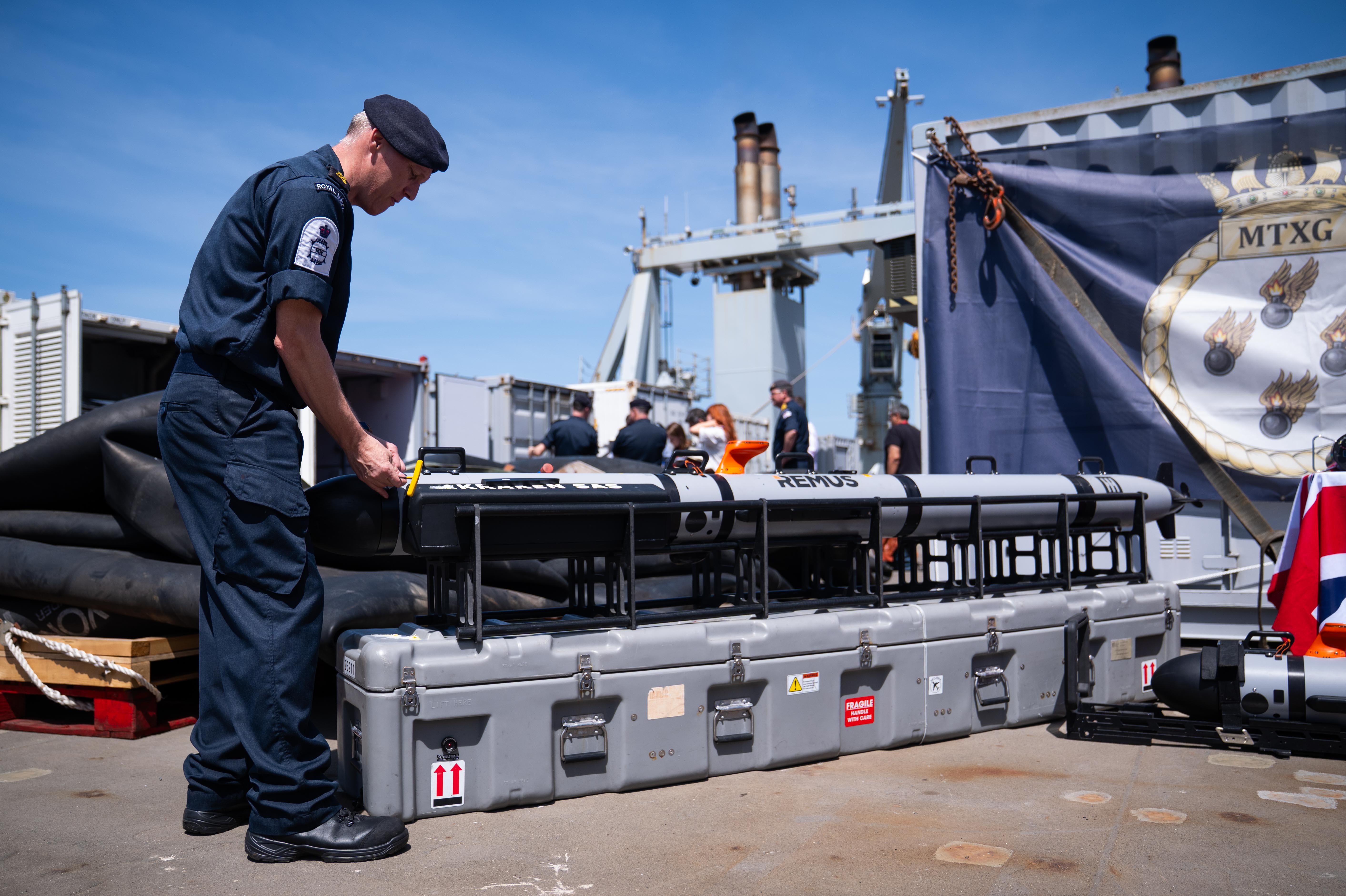 Members of the Royal Navy work on developing mine hunting equipment at RFA Lyme Bay, Gibraltar.